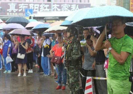 市民为冒雨站岗的军人打伞